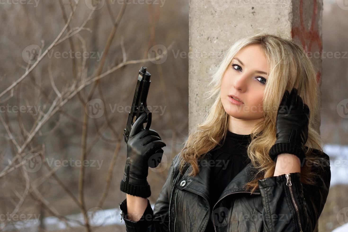 Confused blonde girl with a gun photo