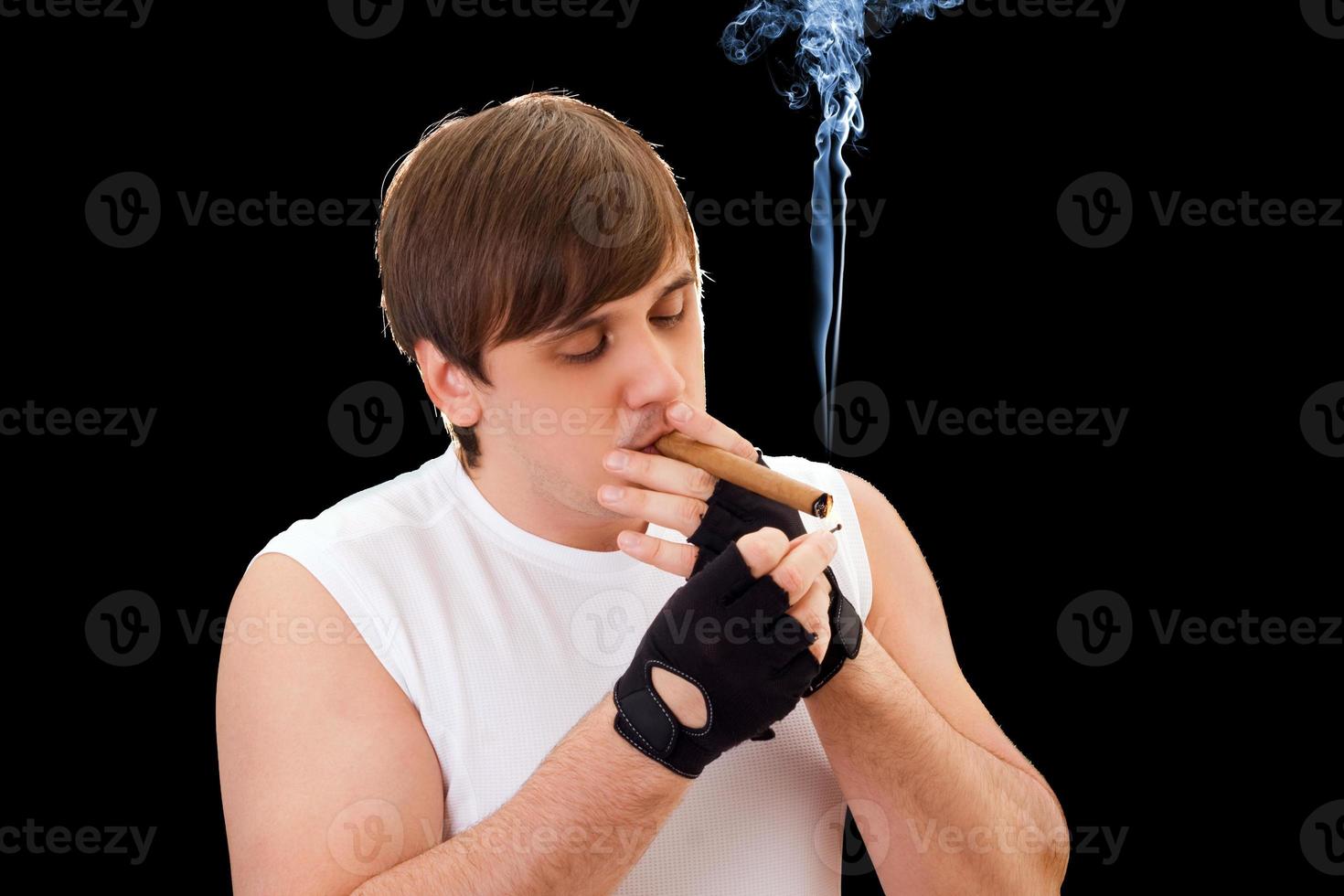 Young man sets fire to a cigar photo