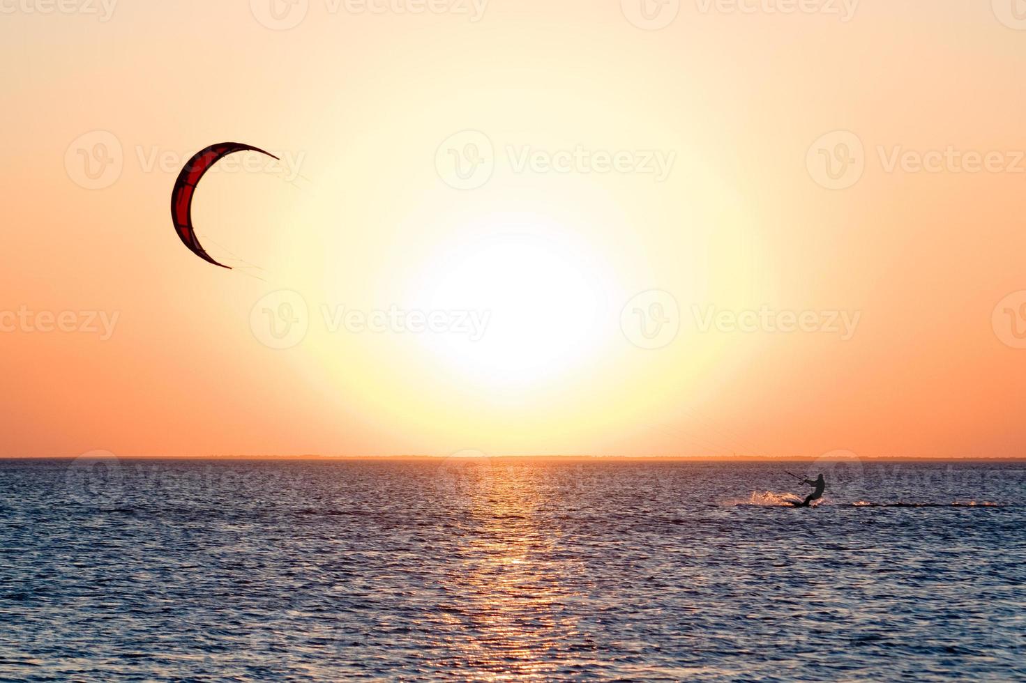 Kitesurfer on a gulf on a sunset photo