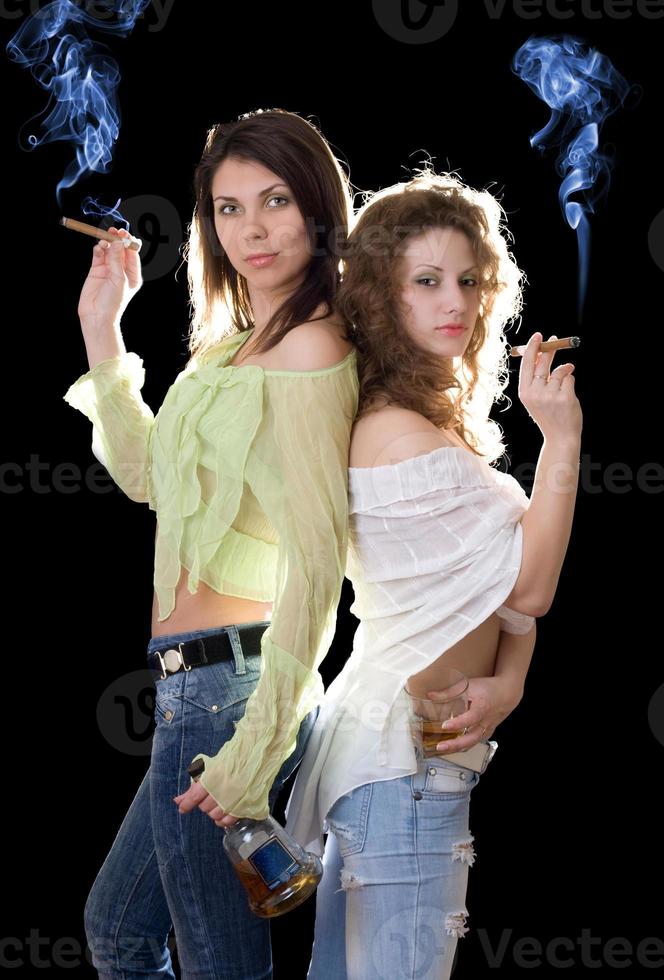 Two pretty girlfriends with a cognac and cigars photo