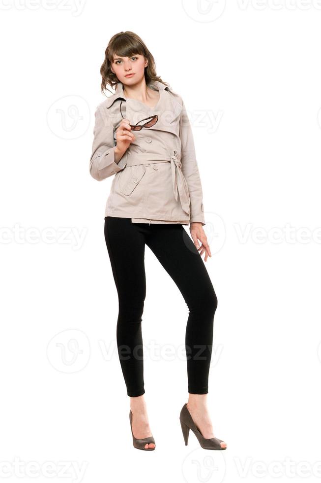 Attractive girl wearing a coat and black leggings. Isolated photo