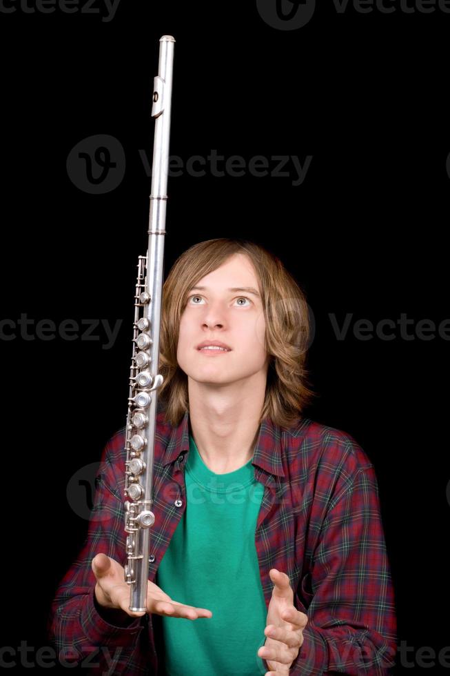 The young man plays with a flute photo