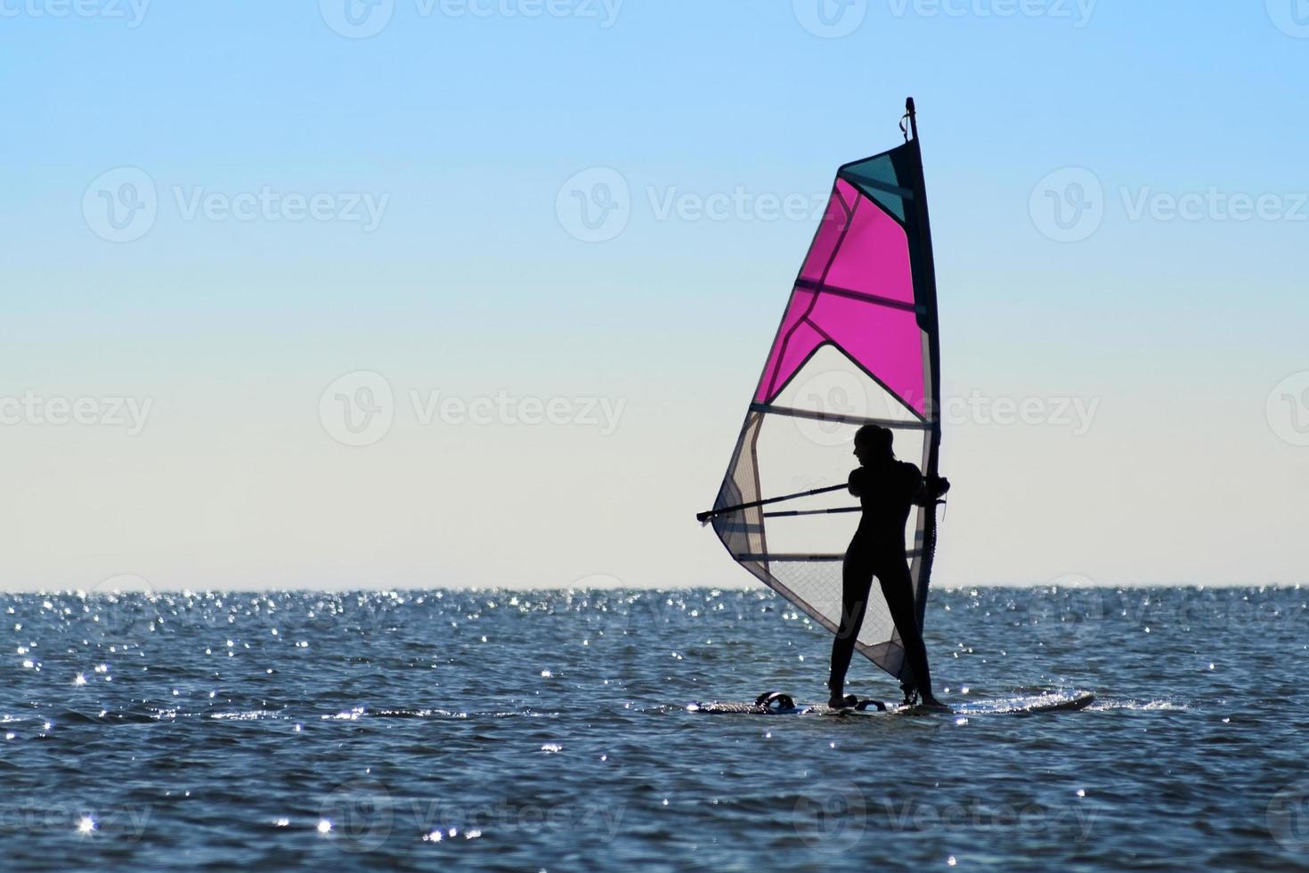 Silhouette of a girl windsurfer photo