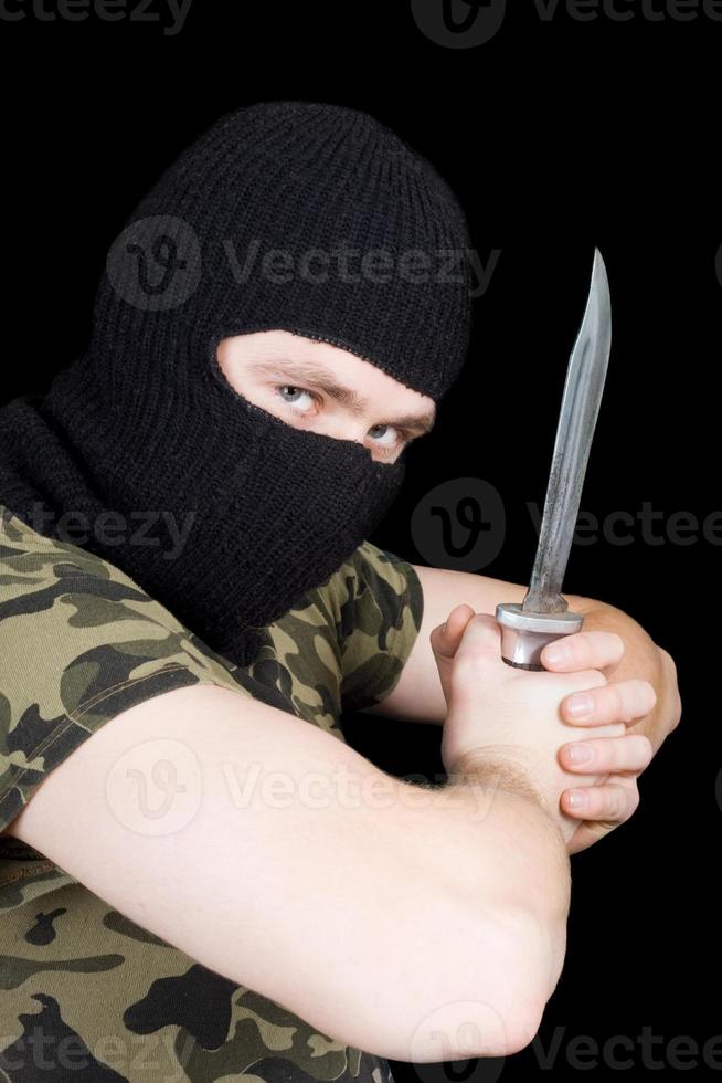 The criminal with a knife in a black mask photo