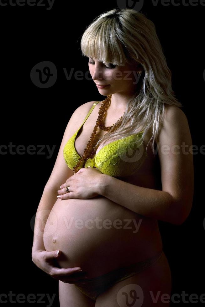 joven embarazada en lencería amarilla. aislado foto