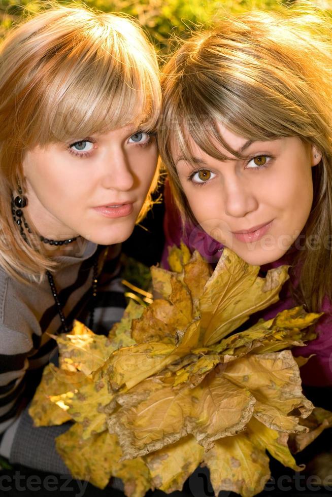 retrato de las dos jóvenes rubias con hojas de otoño foto