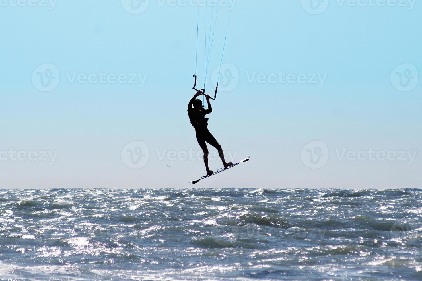 Silhouette of kite surfer in a sea photo
