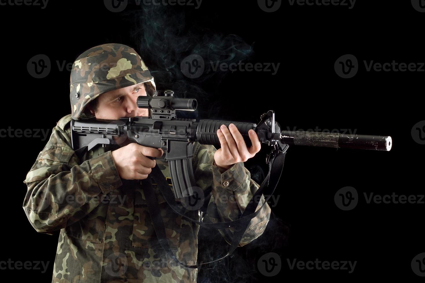 soldado alertado manteniendo una pistola humeante foto
