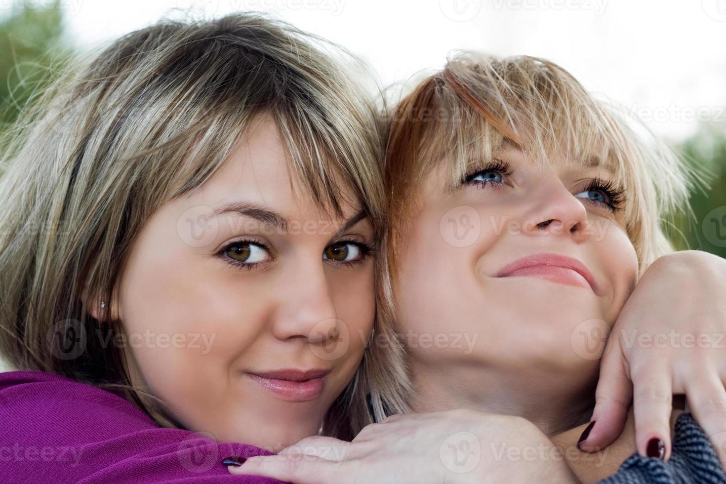 retrato de las dos mujeres jóvenes sonrientes al aire libre foto