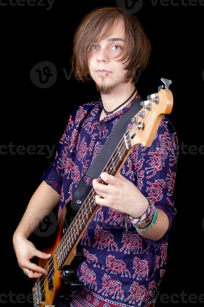 The young man with a guitar. Isolated on a black photo