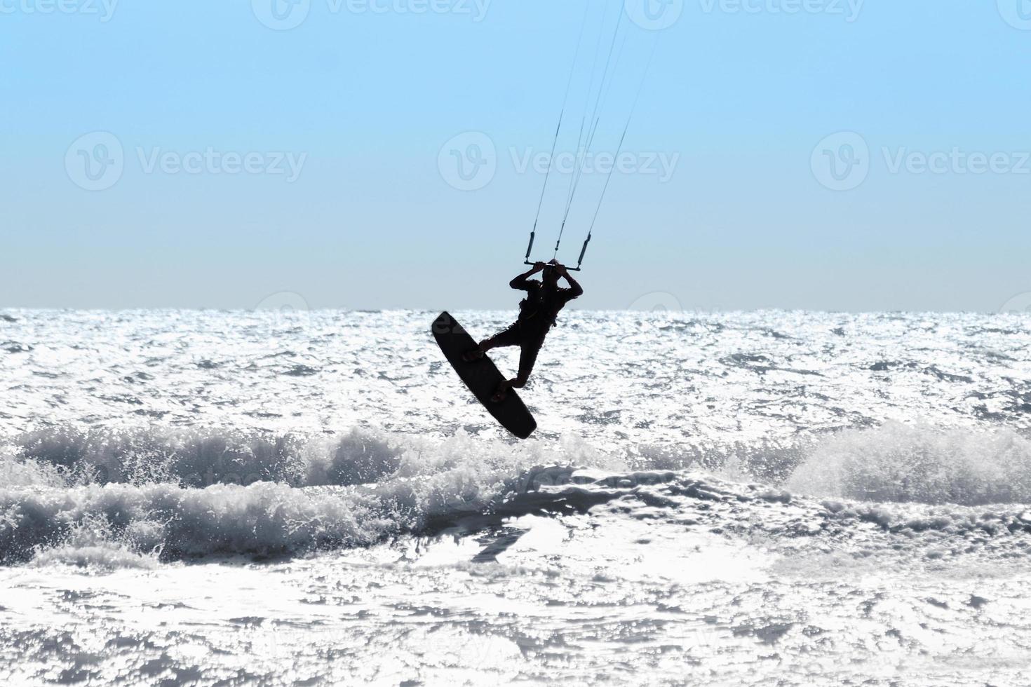 Silhouette of kite surfer photo