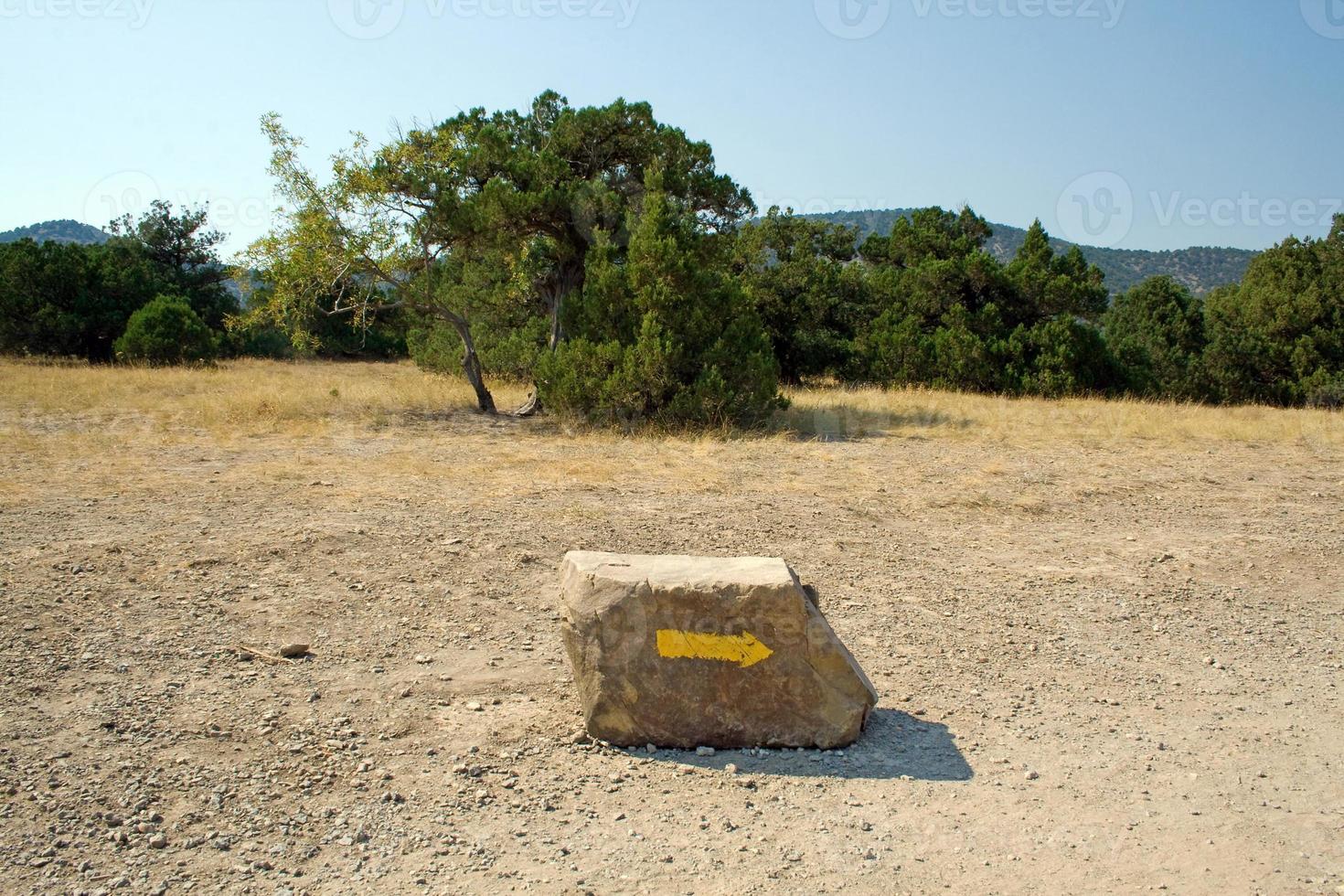 flecha en una piedra, especificando una dirección en las montañas foto