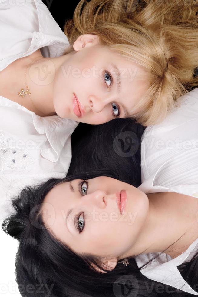 Portrait of lying young blonde and brunette photo