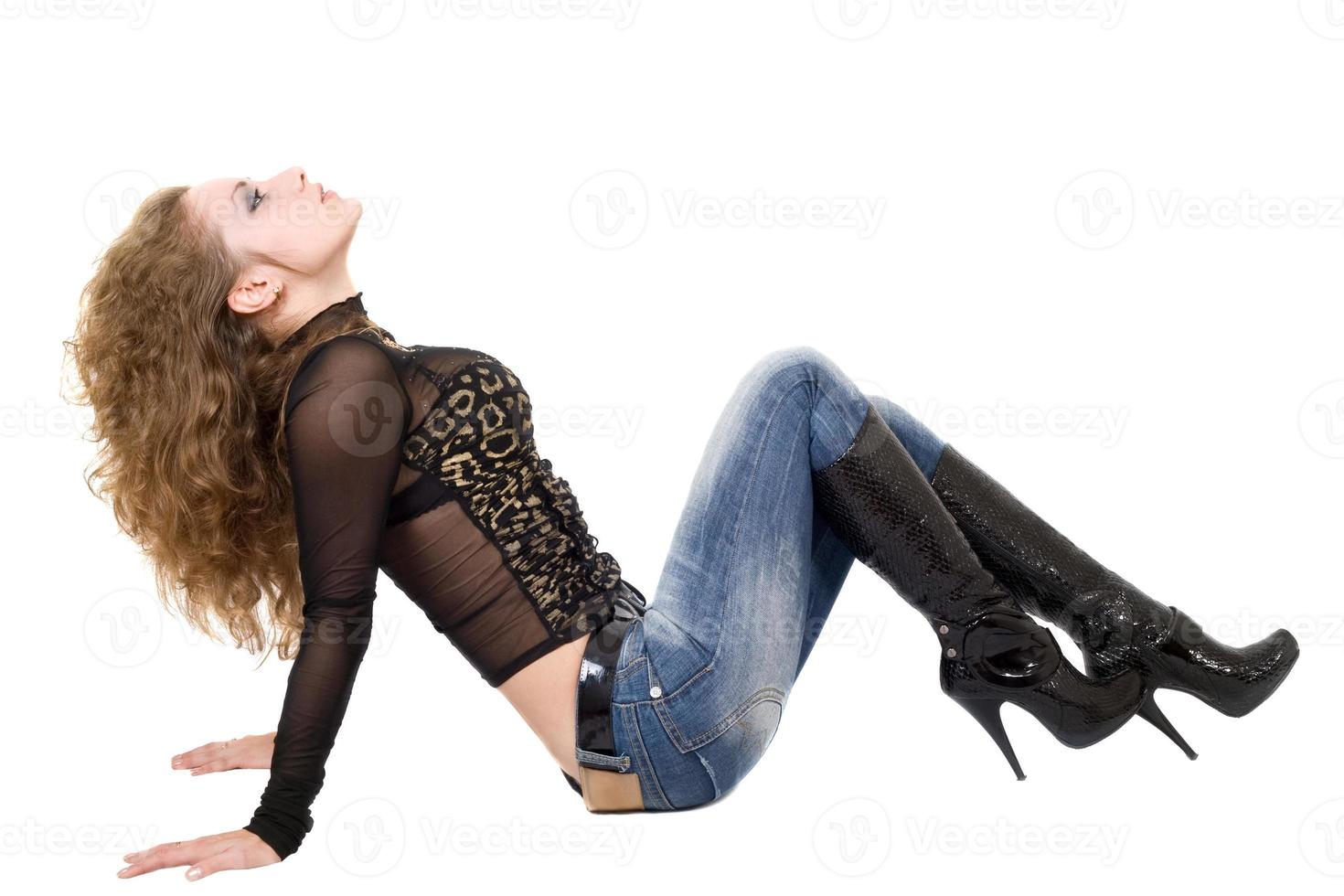 The young woman in blue jeans and black boots. Isolated photo