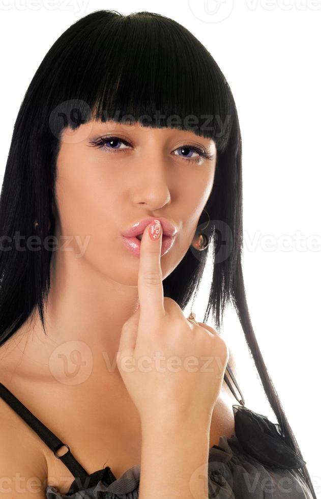 Young woman with a finger at lips photo