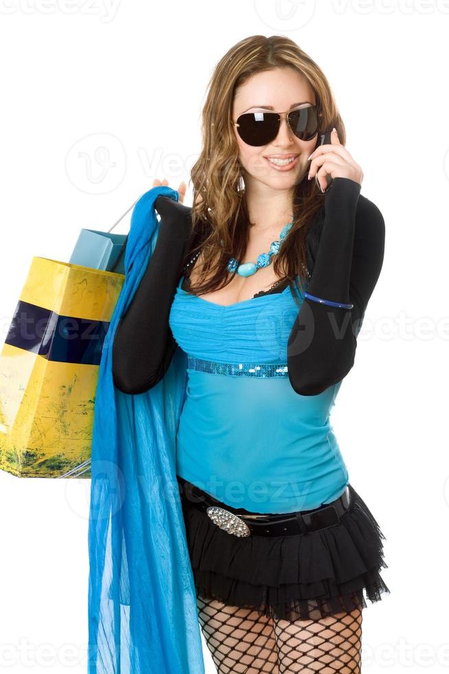 Pretty young woman talking on the phone after shopping photo