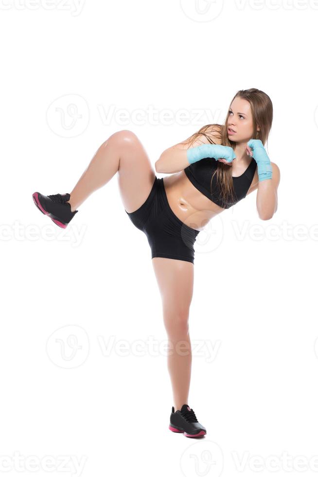 Young woman posing and kicking photo