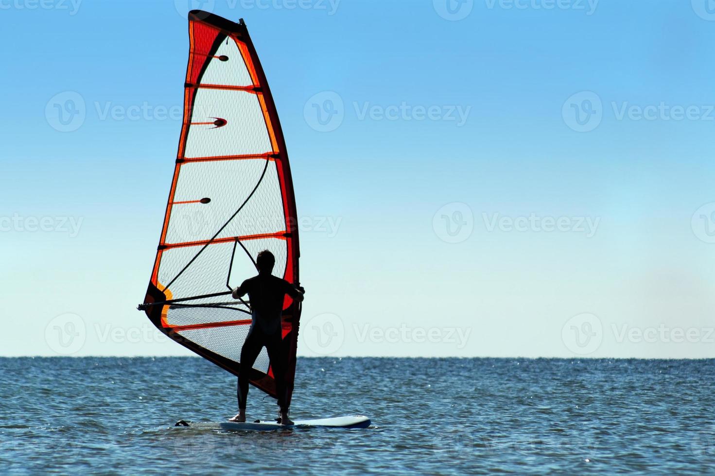 Silhouette of a windsurfer on the sea photo