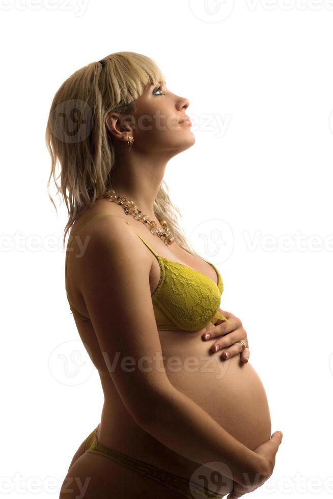 Happy pregnant young woman in yellow lingerie photo