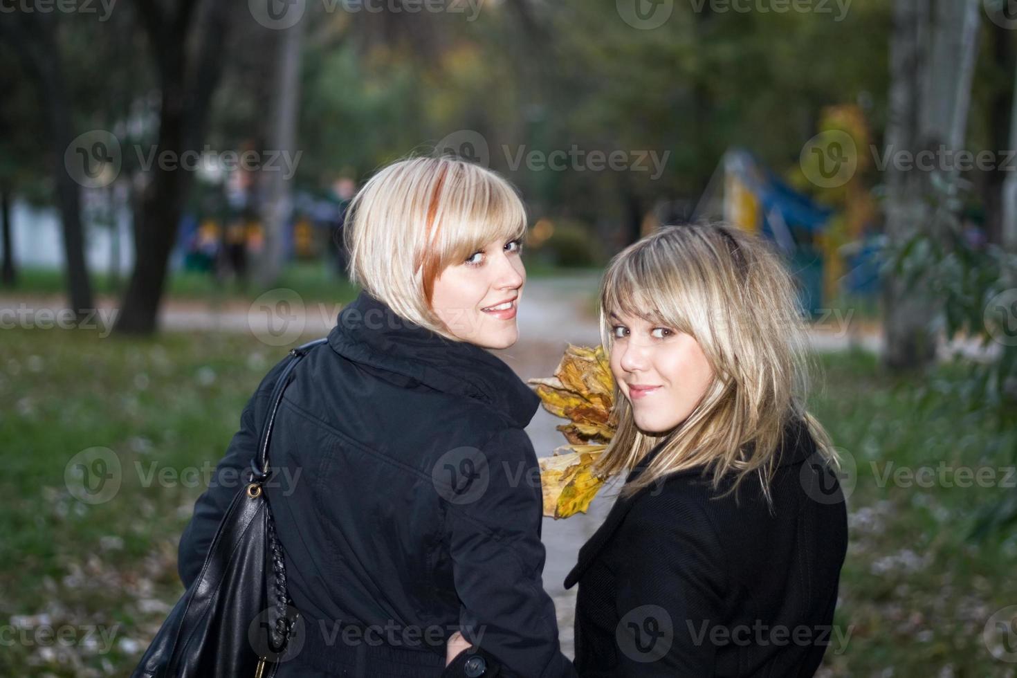 retrato de las dos mujeres jóvenes en el parque de otoño foto