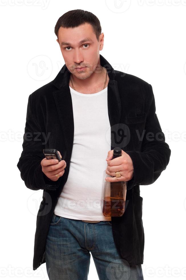 hombre con un teléfono y una botella de whisky escocés foto