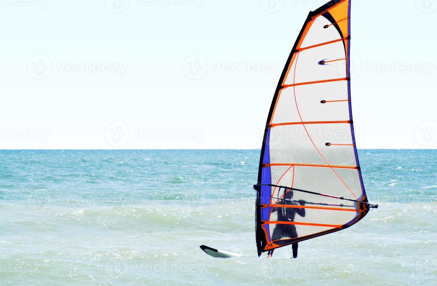 Silhouette of a windsurfer on the sea in the afternoon photo