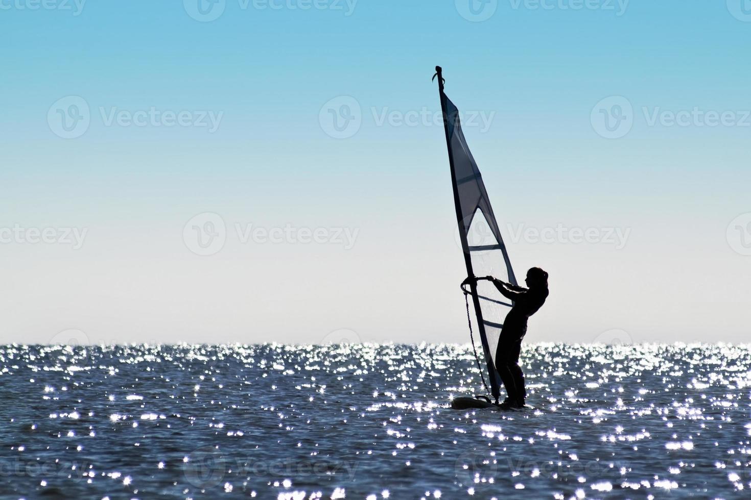 Silhouette of a girl windsurfer photo