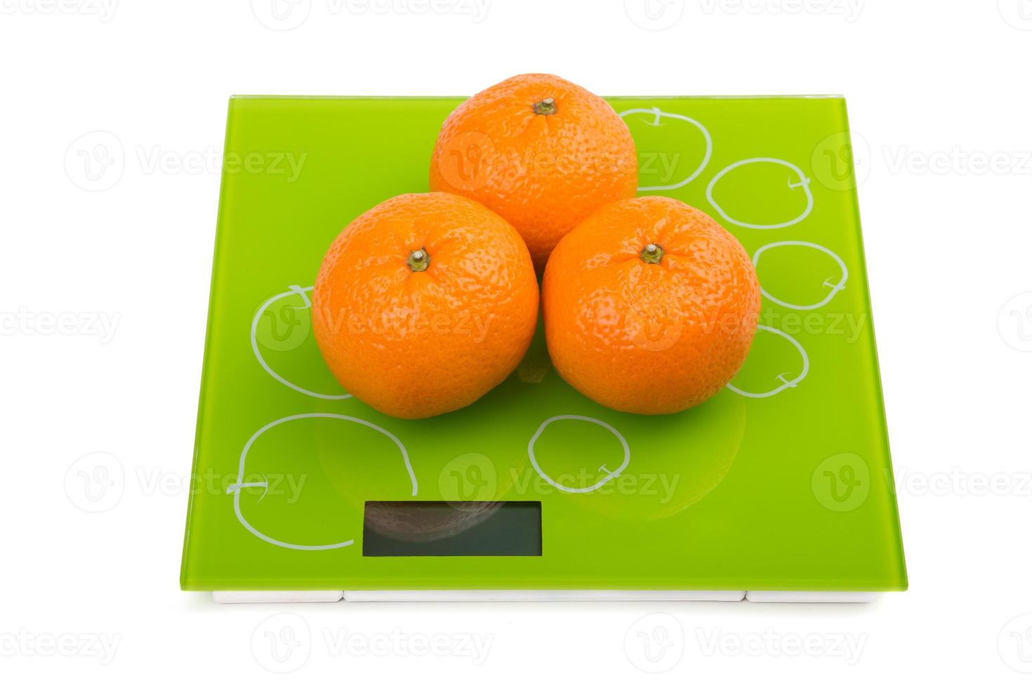 Three sweet mandarin on scales photo