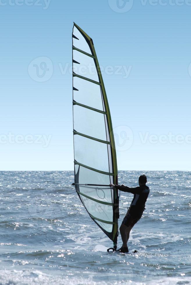 Silhouette of a windsurfer on a sea photo
