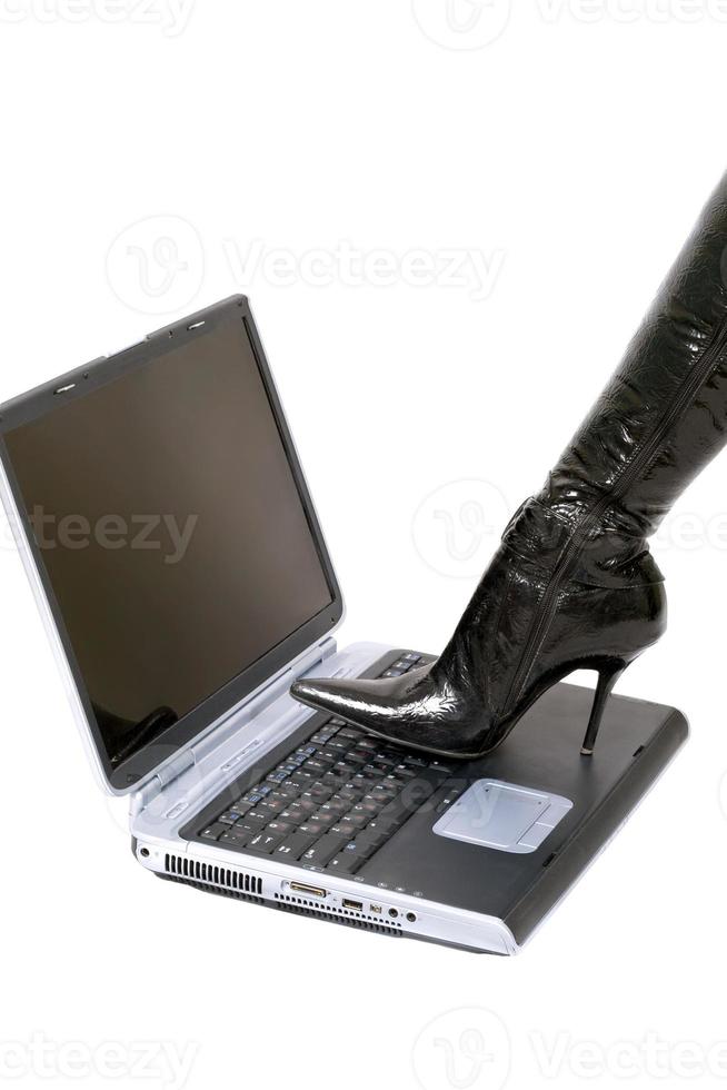 Woman leg over laptop. Isolated on white photo