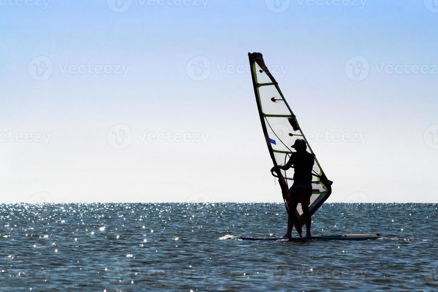 Silhouette of a windsurfer photo