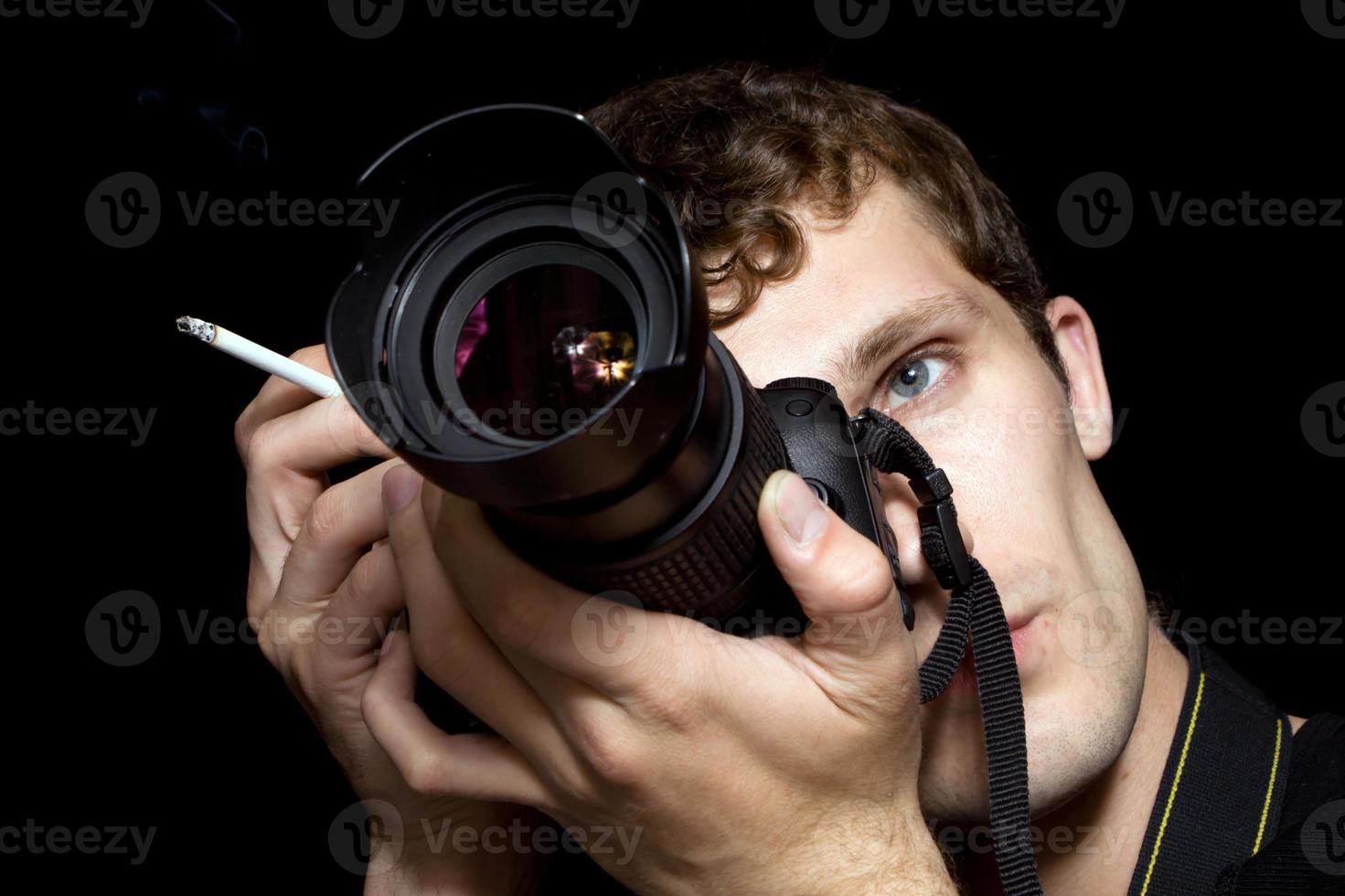 The young man - photographer behind work. Isolated on a black background 5 photo