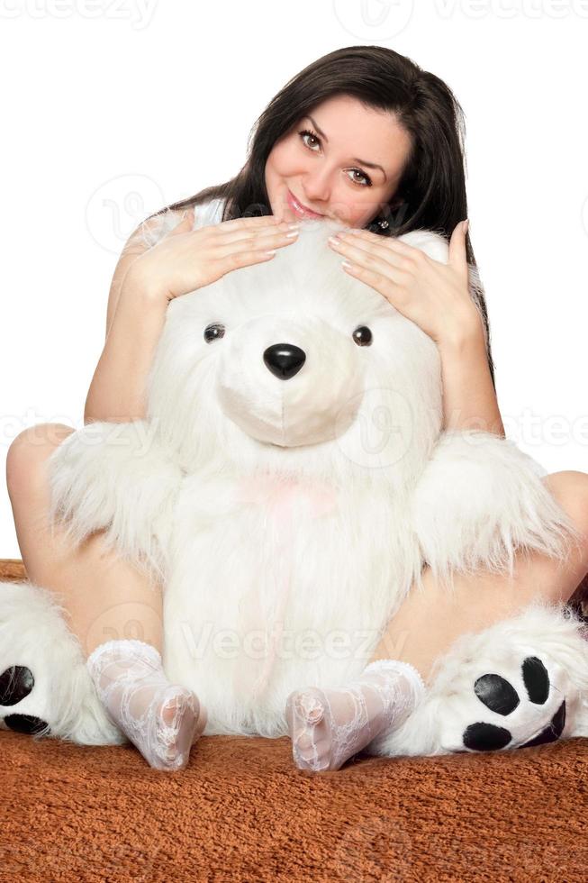 Beautiful girl sitting in an embrace with a teddy bear photo