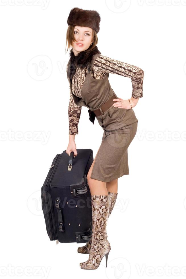 Young beautiful woman with a heavy suitcase. Isolated photo