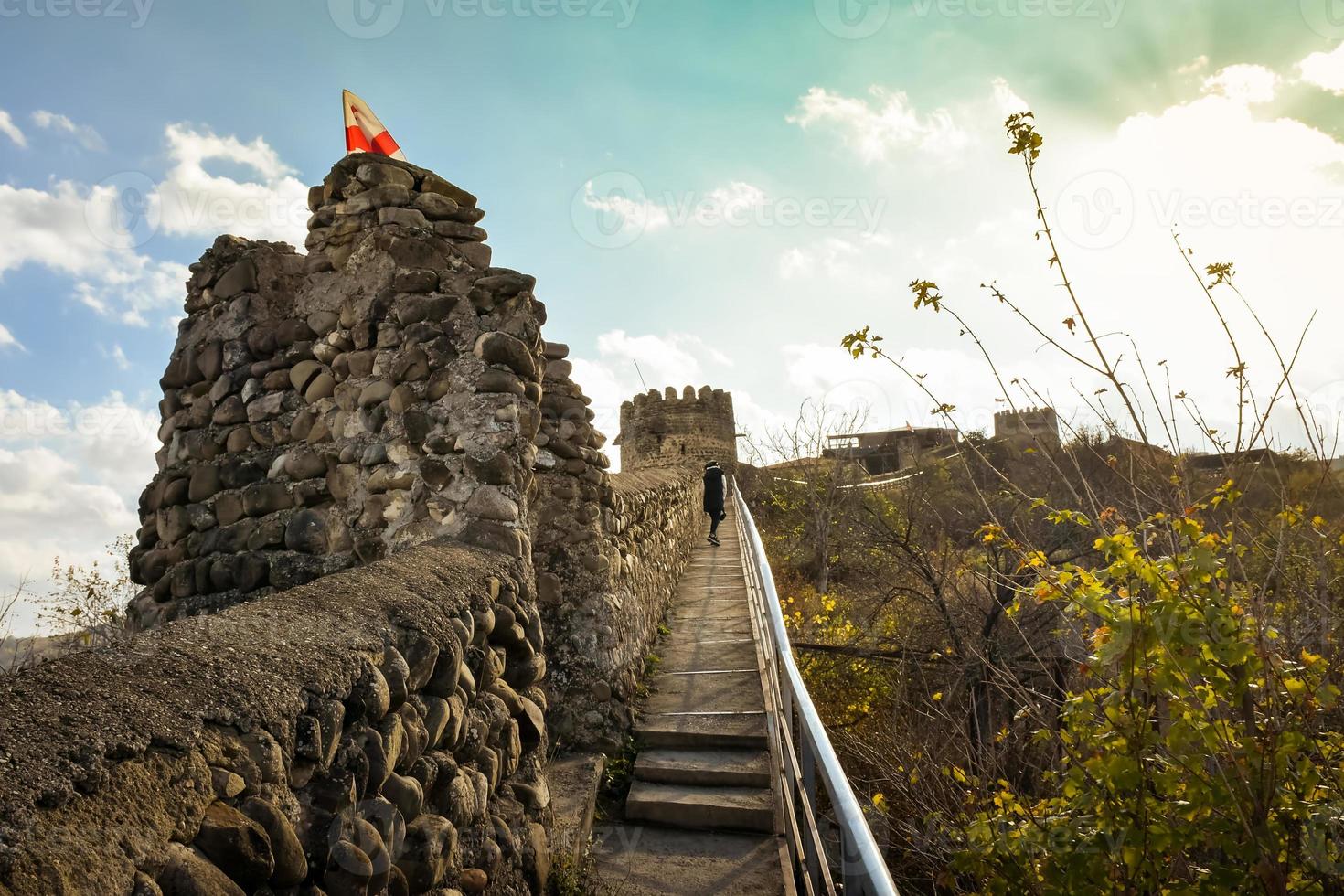 Tourist walk Sighnaghi walls of the old fortress with the Georgian flag with sky background. Popular destination city of love Sighnaghi, Kakheti region. New attraction photo