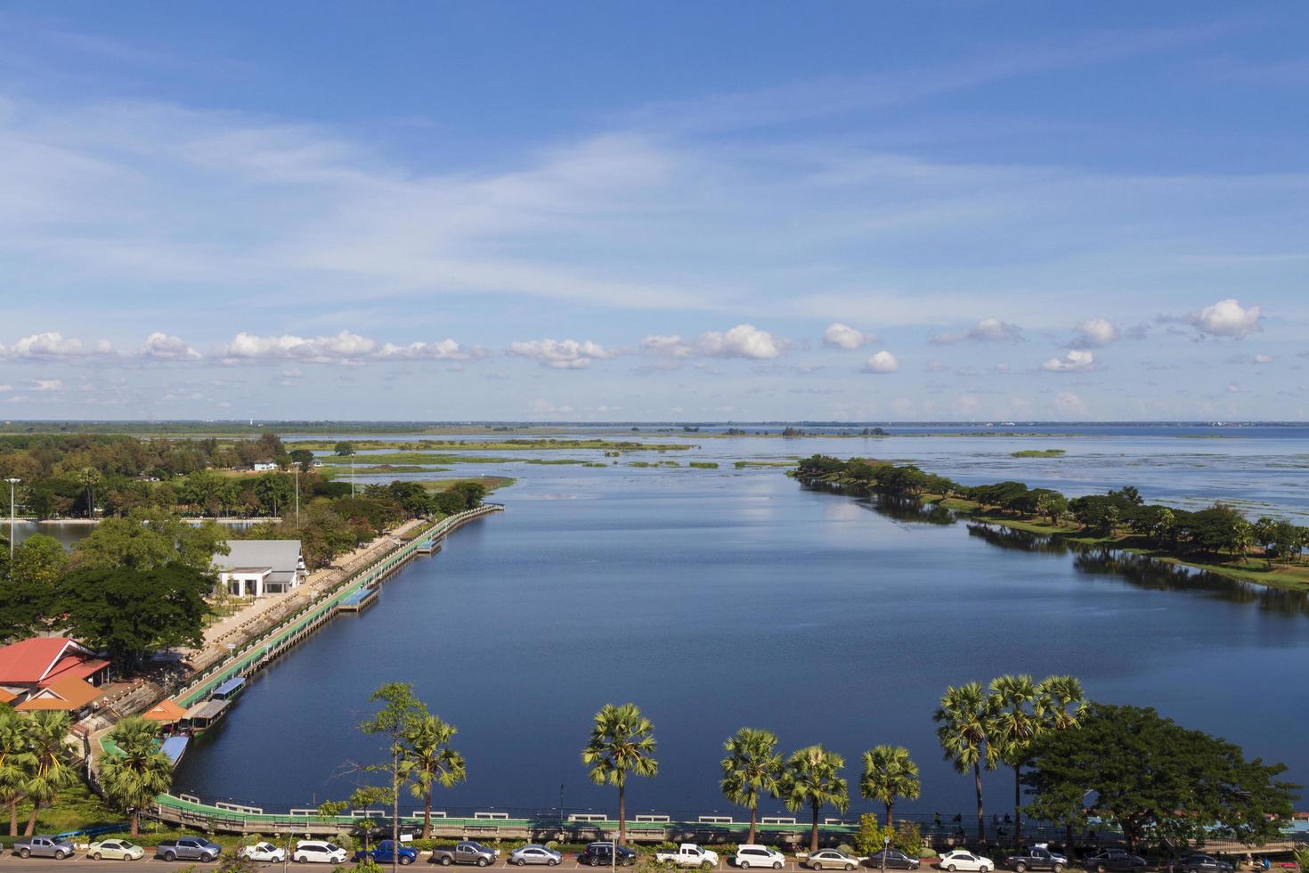 ángulo alto del punto de vista de nong han sakon nakhon. árboles verdes frescos a orillas del río y cielo despejado. carriles bici en el río y embarcadero turístico. foto