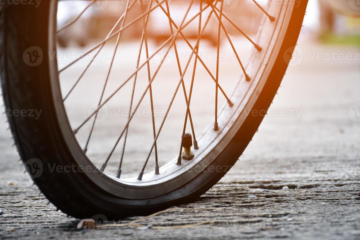 Closeup view of bike flat wheel or bike flat tire which parked by the road and waiting to fix. photo