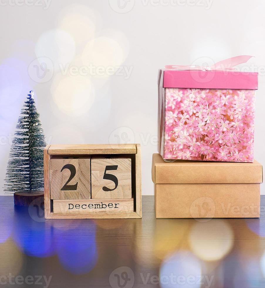 wooden retro calendar from blocks, Christmas decorative tree and cardboard boxes with gifts photo