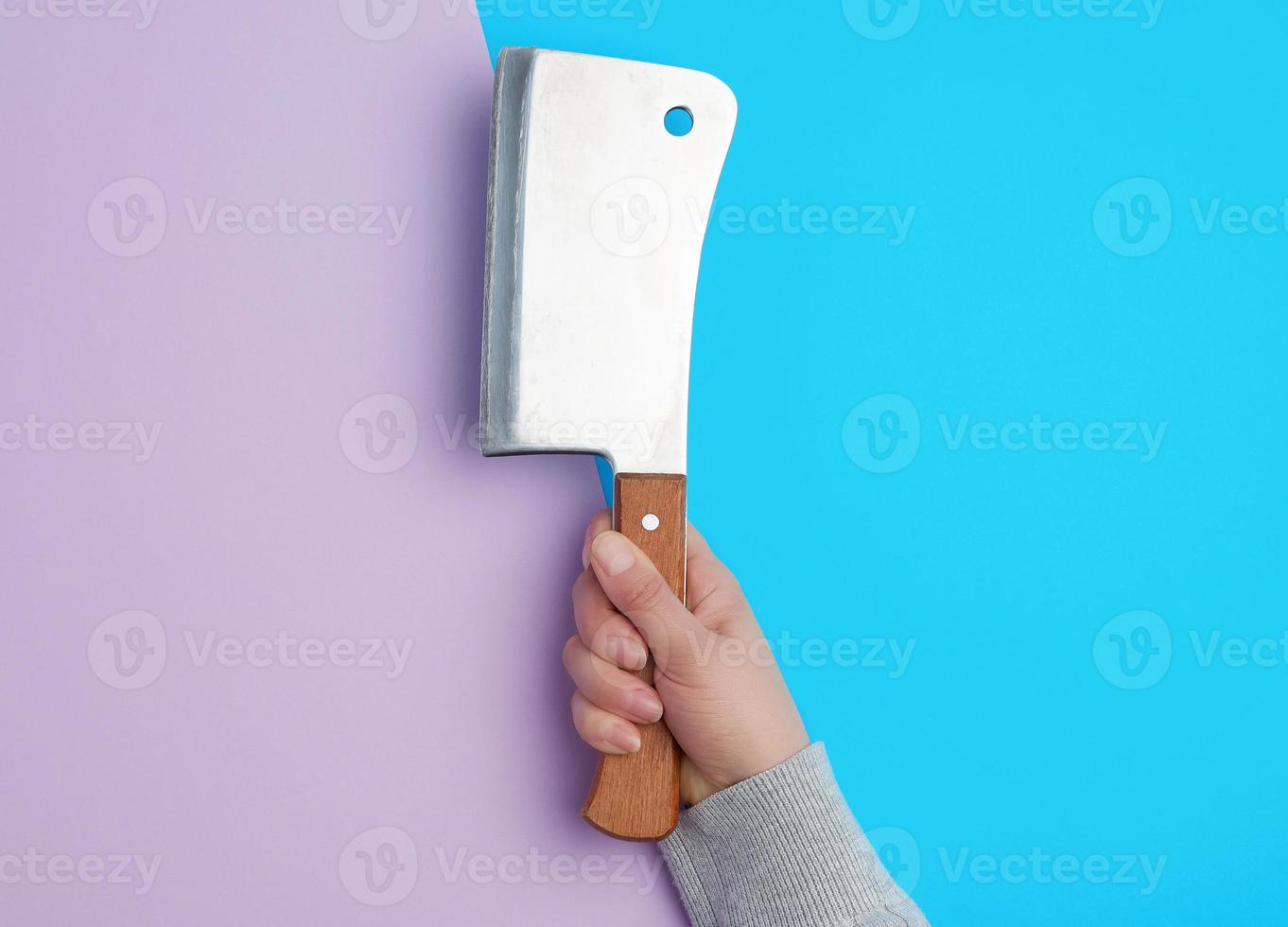 large metal knife for cutting meat in a female hand photo