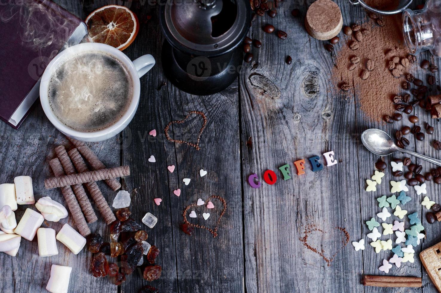 Abstract background with sweets and a cup of black coffee on a gray wooden surface photo