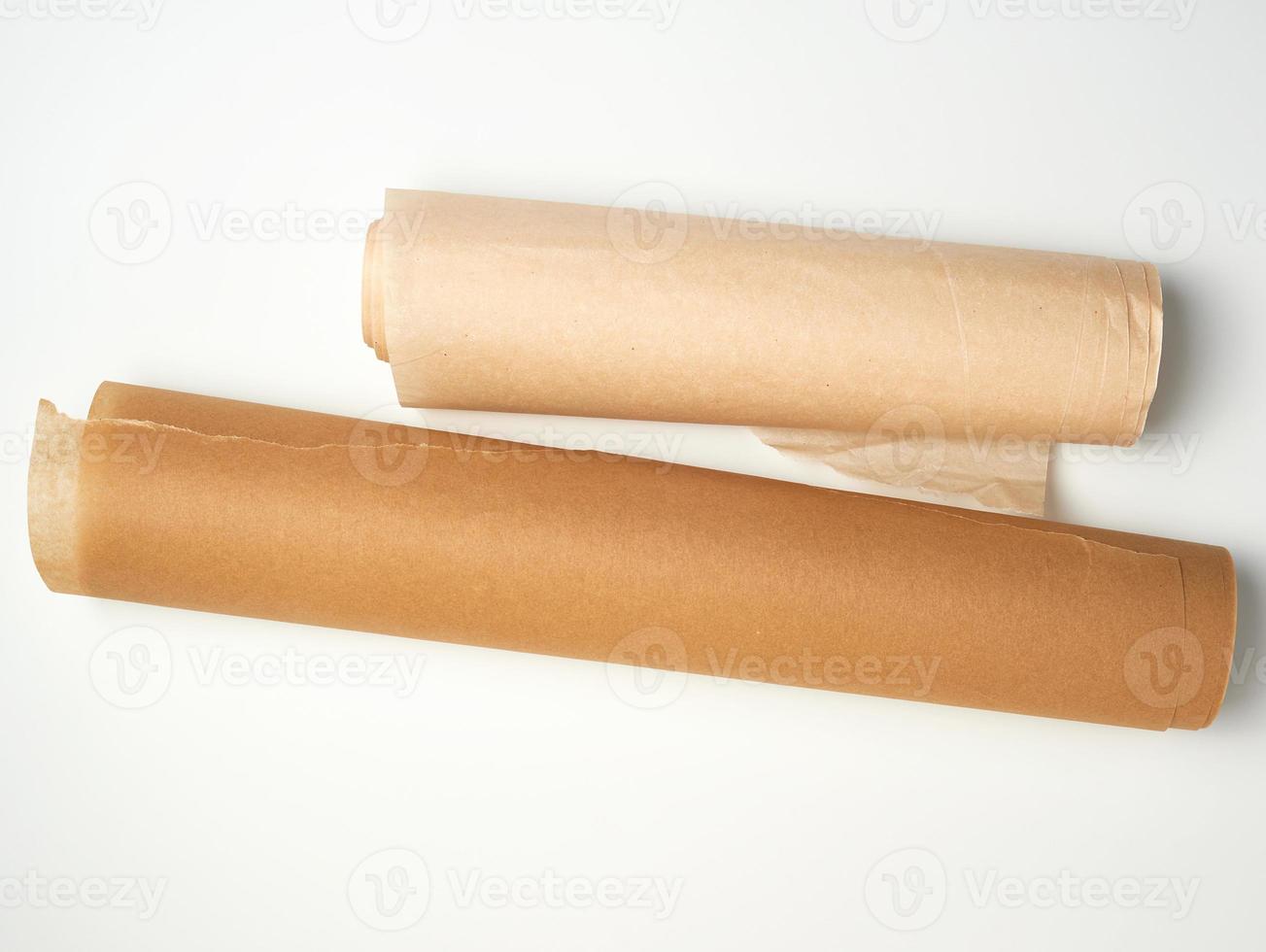 two rolls of brown parchment paper for baking on a white background photo