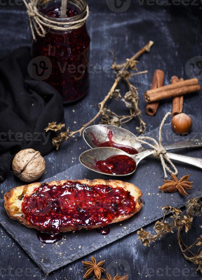 tosta de pan de trigo blanco untado con mermelada de frambuesa foto