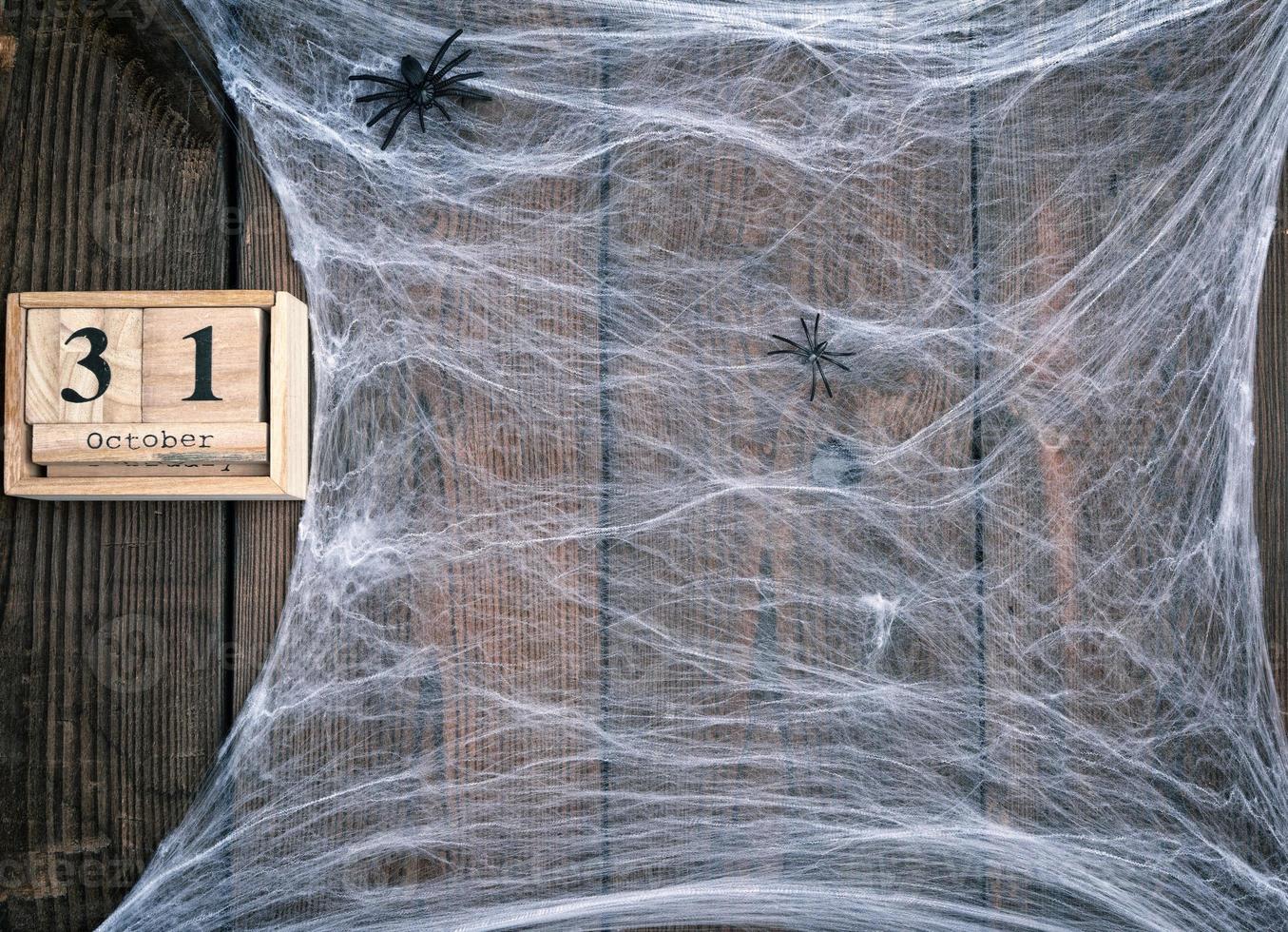 White spider web and wooden retro calendar made of blocks with the date of October 31 photo