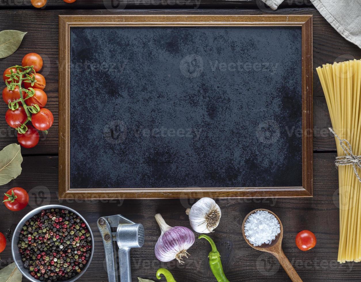 empty black frame and ingredients for cooking pasta photo