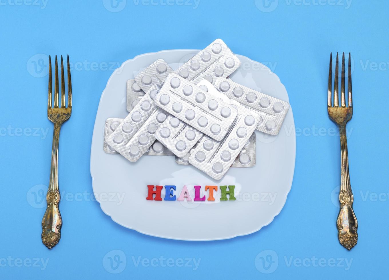 white tablets in a package on a square ceramic plate photo