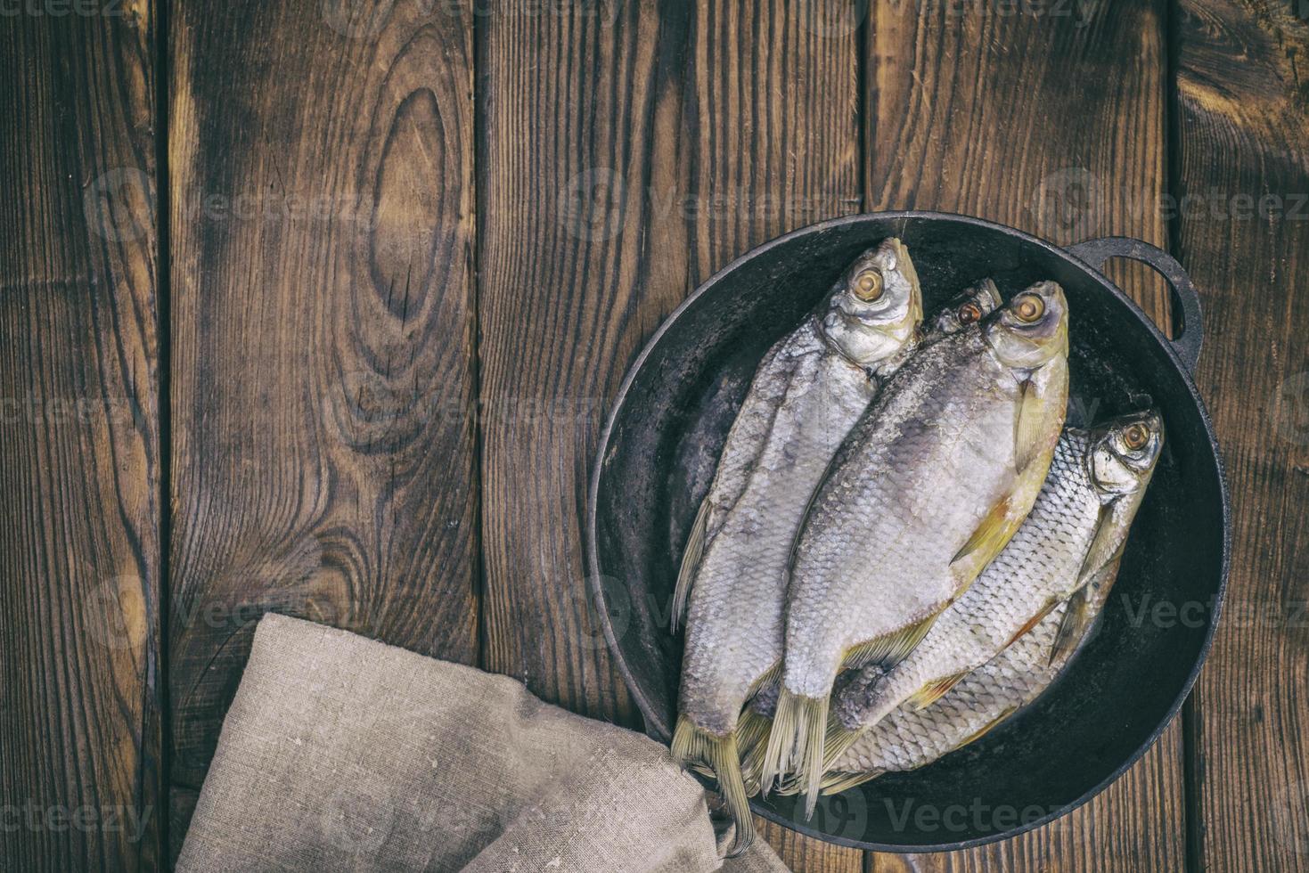 fish ram in a round black cast-iron frying pan photo