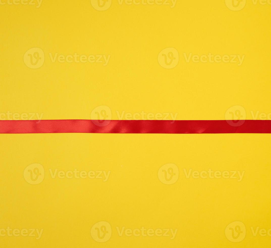 red silk ribbon on a yellow background, festive backdrop photo