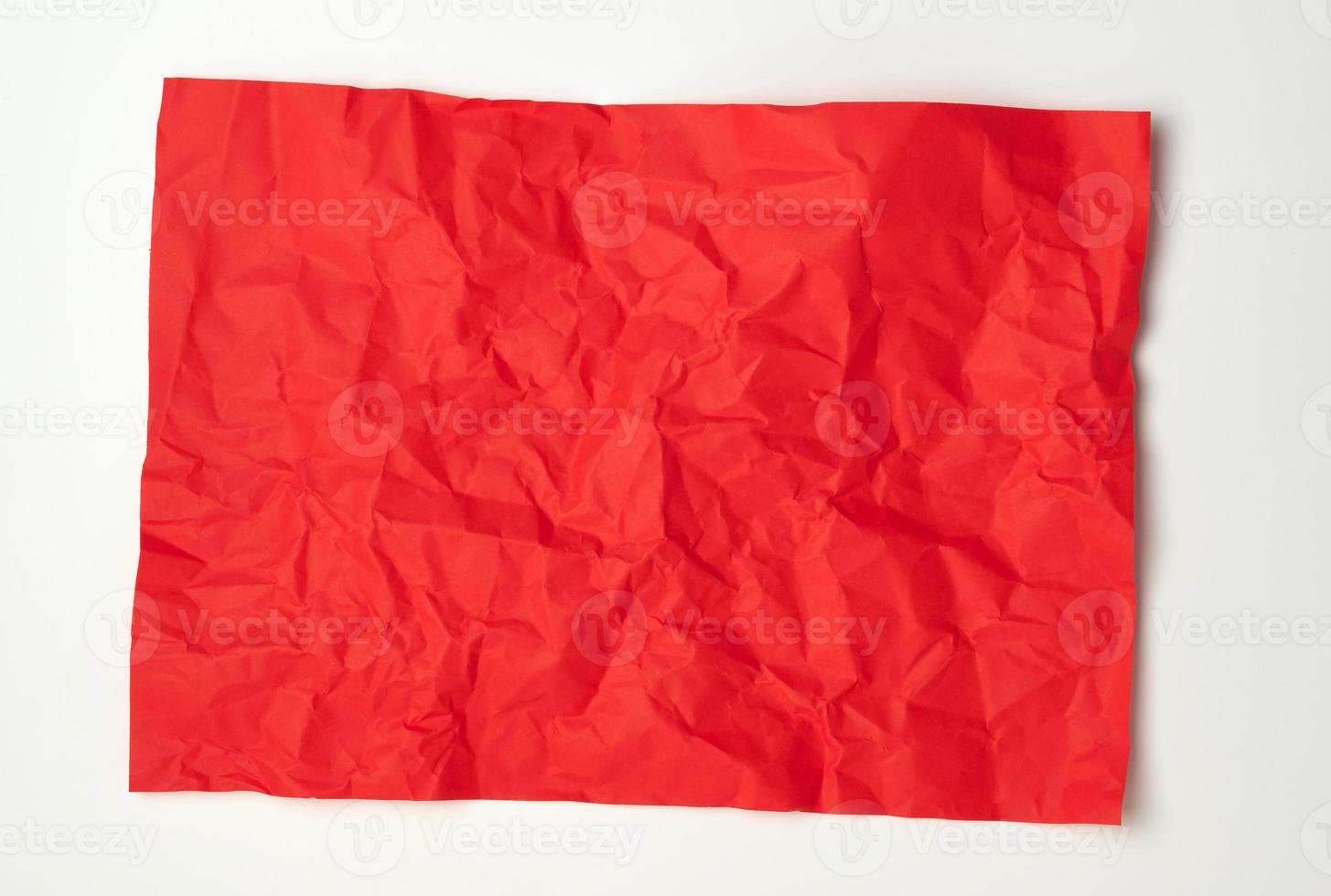 crumpled red rectangular sheet of paper on a white background photo