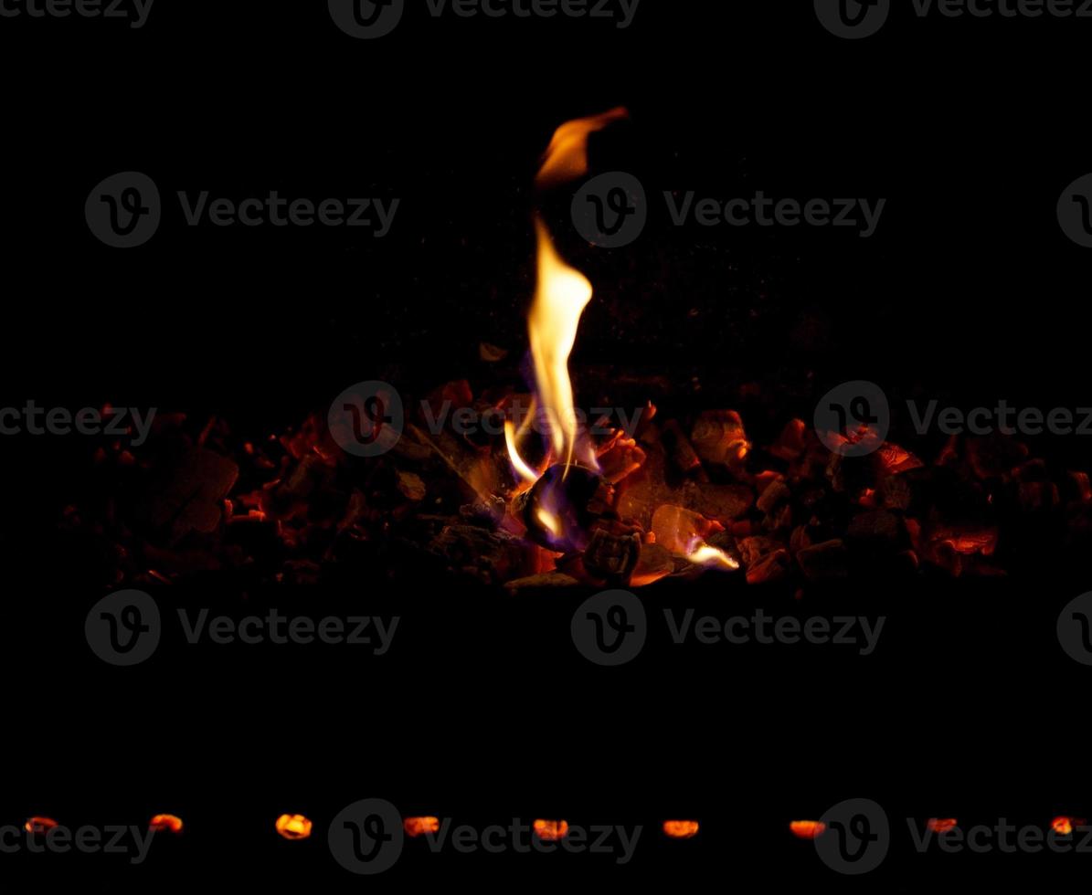 Smoldering coals and fire on a black background photo