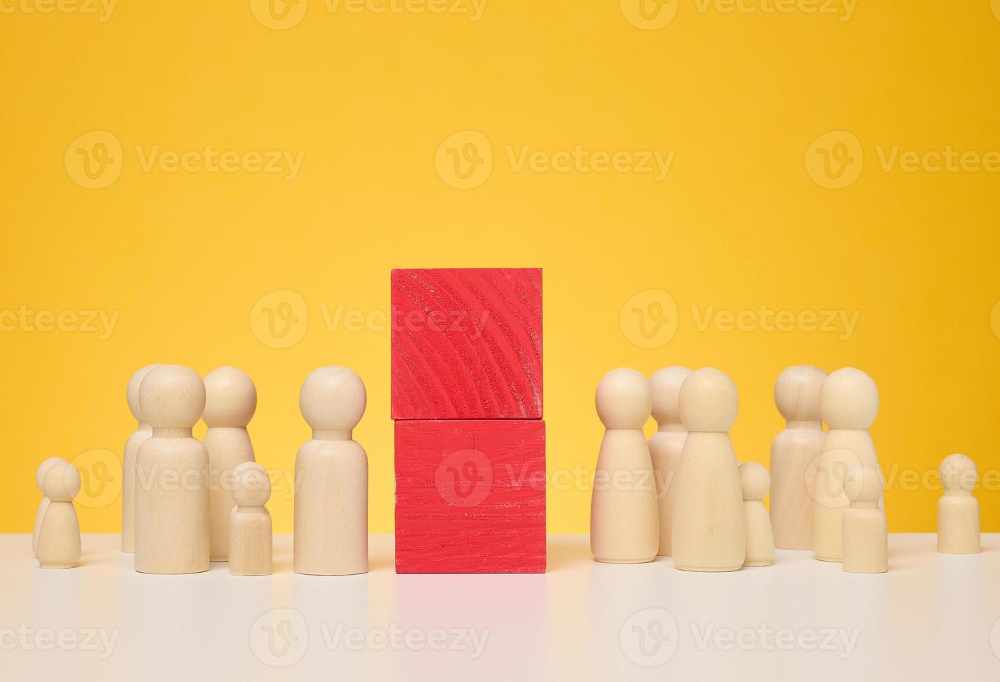 Two crowds of wooden figurines are separated by red blocks. The concept of misunderstanding and separation photo